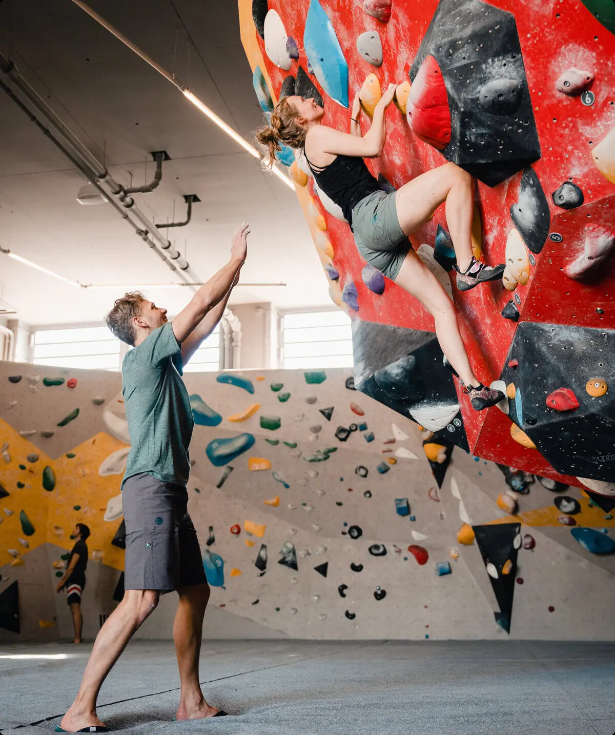 Eine Frau klettert in einer Kletterhalle, ihr Partner sichert sie. | © DAV/Marisa Koch