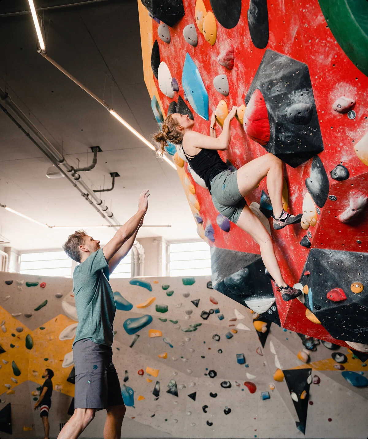 Eine Frau klettert in einer Kletterhalle, ihr Partner sichert sie. | © DAV/Marisa Koch