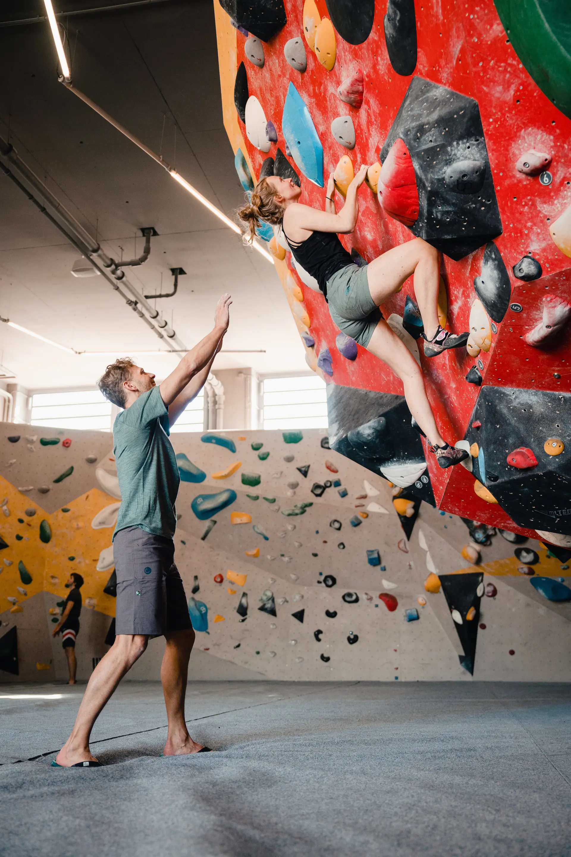 Eine Frau klettert in einer Kletterhalle, ihr Partner sichert sie. | © DAV/Marisa Koch